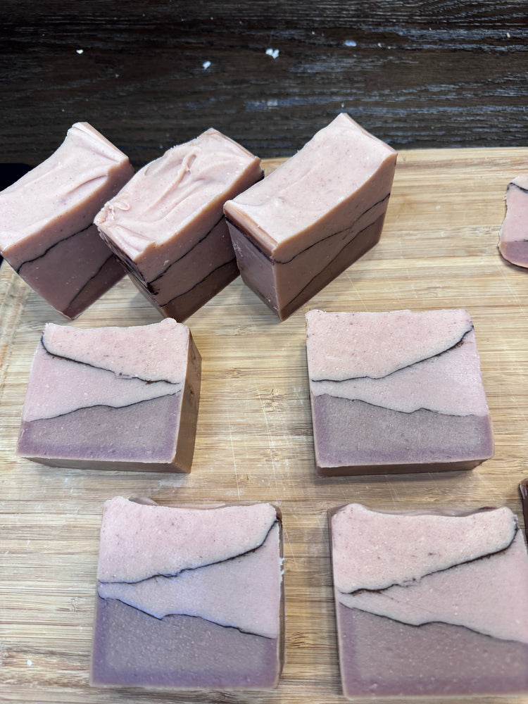 Seven bars of layered soap on wooden surface