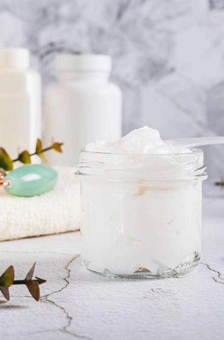 Jar of white lotion on marble surface