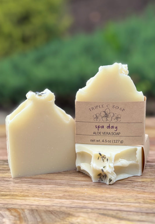 Three cream colored bars of soap with Spa Day aloe vera soap label.