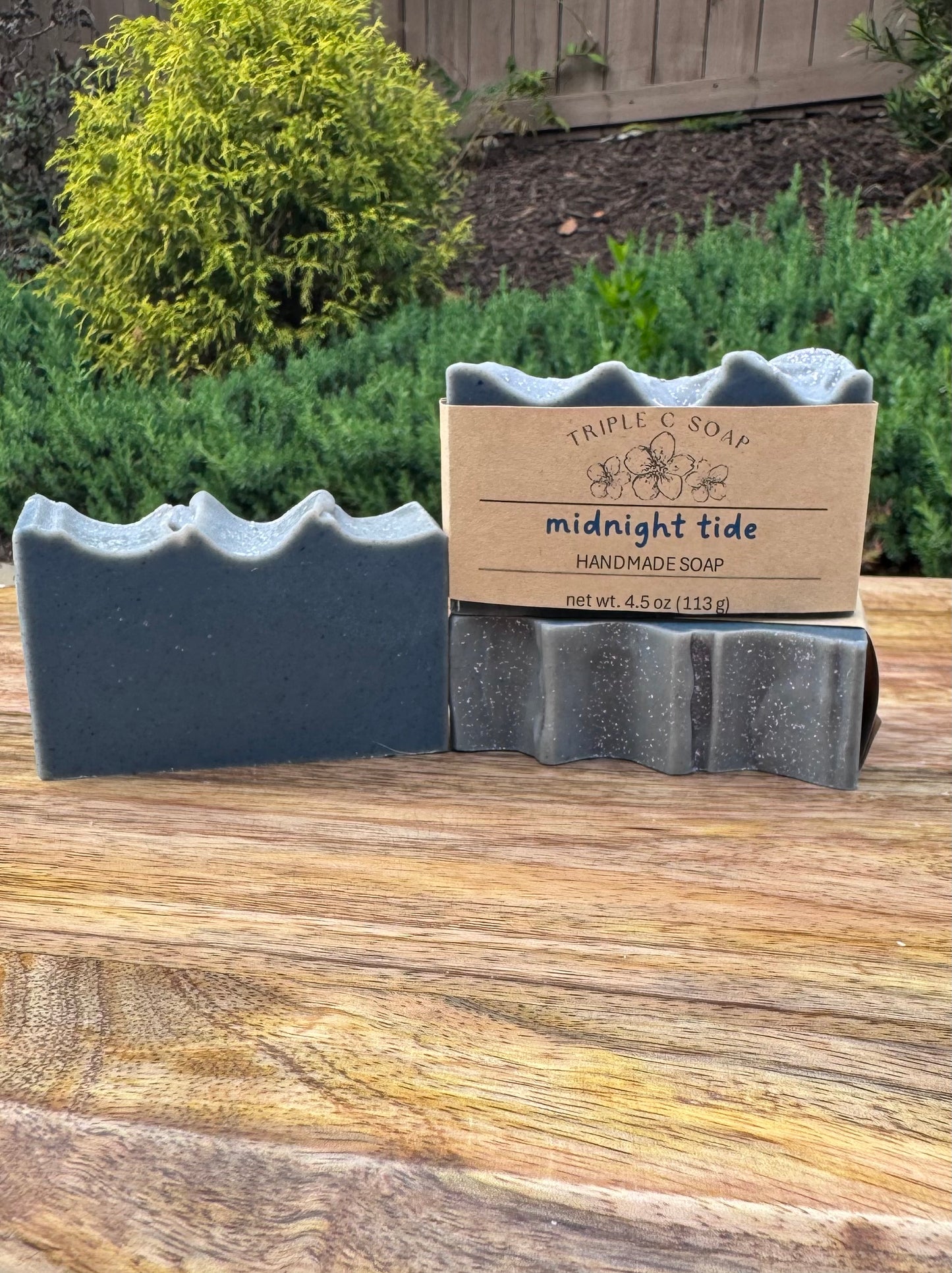 Three bars of handmade soap labeled 'Triple C Soap' on a wooden surface.