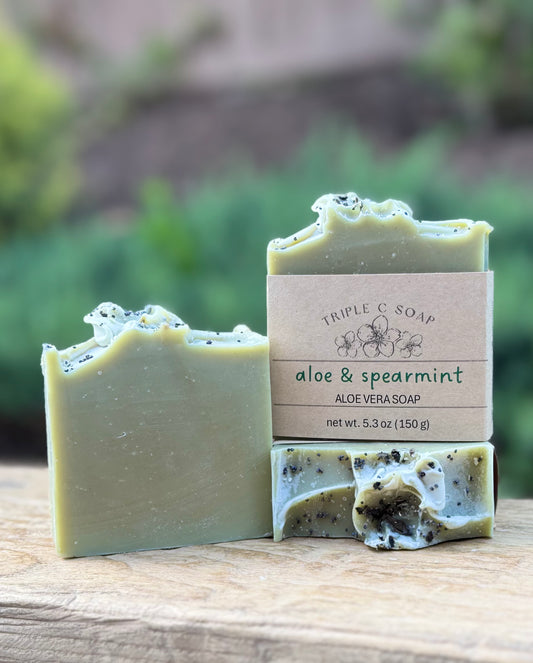 Three aloe vera soaps with spearmint on a wooden surface, labeled 'Triple C Soap'.