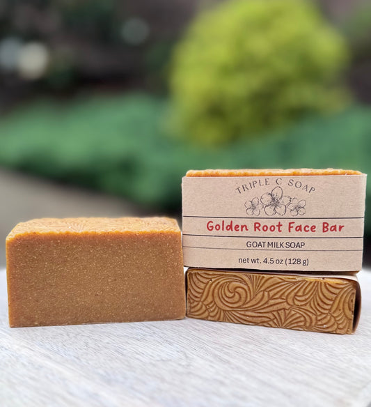 Three Golden Root Face Bars of goat milk soap bar on wooden surface with a blurred natural background