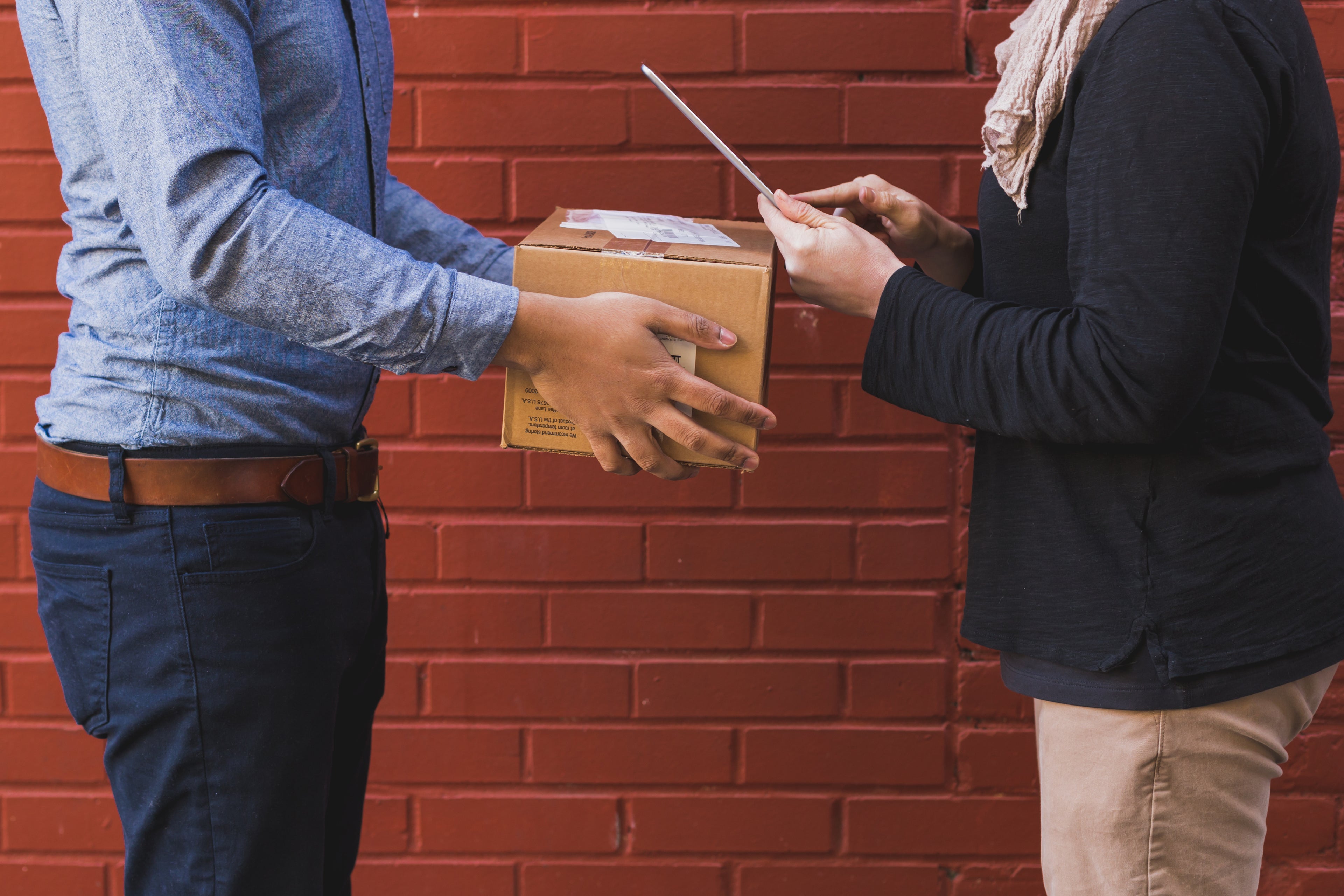 Person handing a shipping box to another person